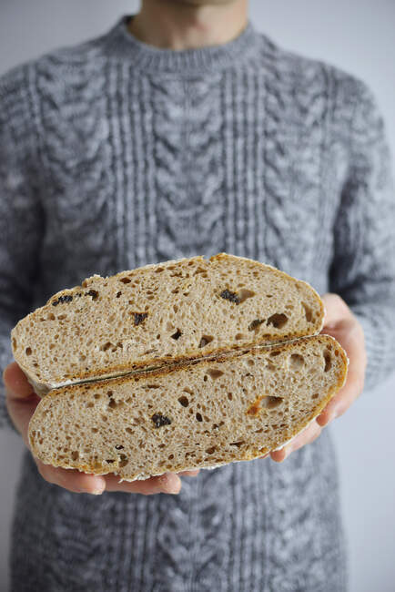 Чоловік тримає половинки хліба в руках — стокове фото