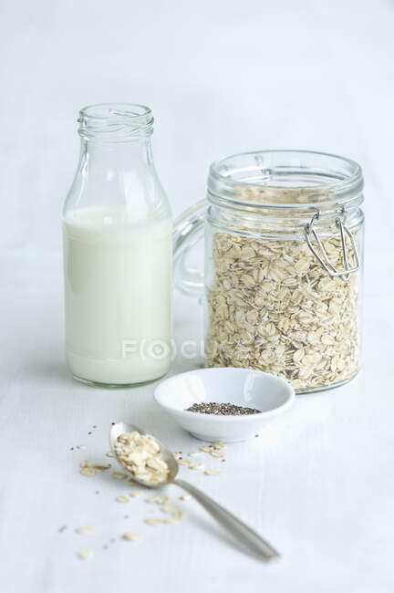 Jarra de cereal com garrafa de leite, aveia e sementes de chia — Fotografia de Stock
