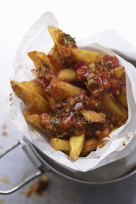Chips with sauce in a paper cone — Stock Photo