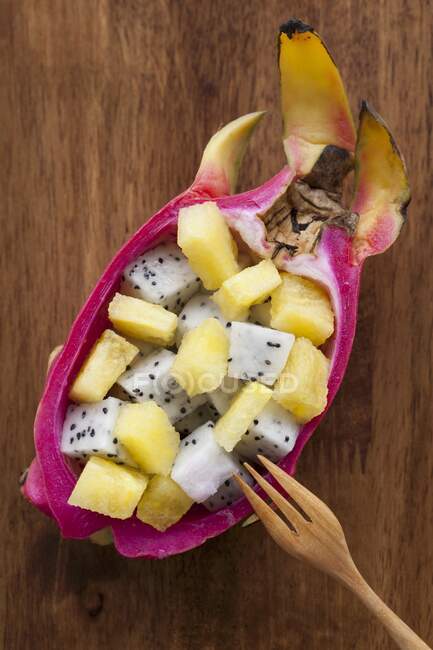 Salade de fruits exotiques servie dans un fruit du dragon — Photo de stock