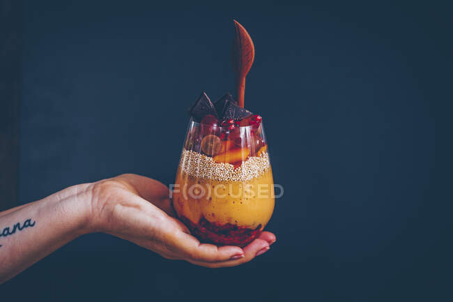 Una mano che tiene un bicchiere di parfait — Foto stock
