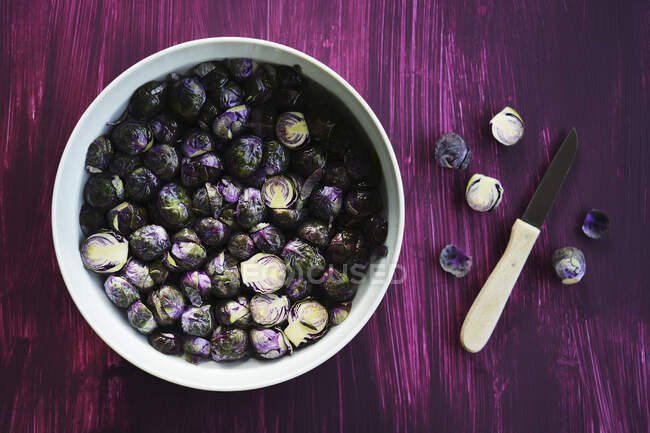 Fresh Brussels sprouts in a bowl of water — Stock Photo