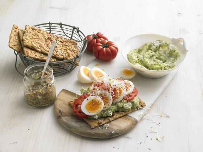 Knäckebrot mit Avocado und Quark, gekochten Eiern, Tomaten und Rosenkohl — Stockfoto