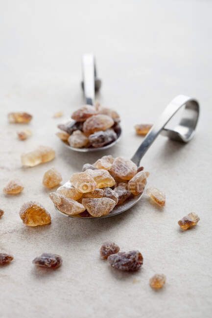 Azúcar de roca morena en cucharas — Stock Photo