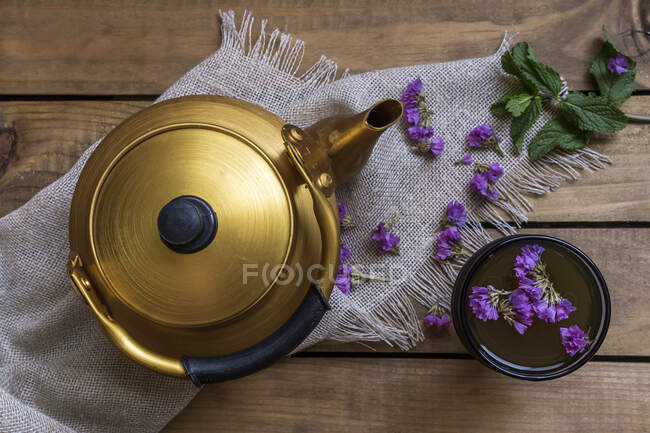 Teiera e tazza di tè verde con menta e fiori commestibili — Foto stock