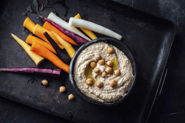 Hummus and colourful carrot sticks — Stock Photo