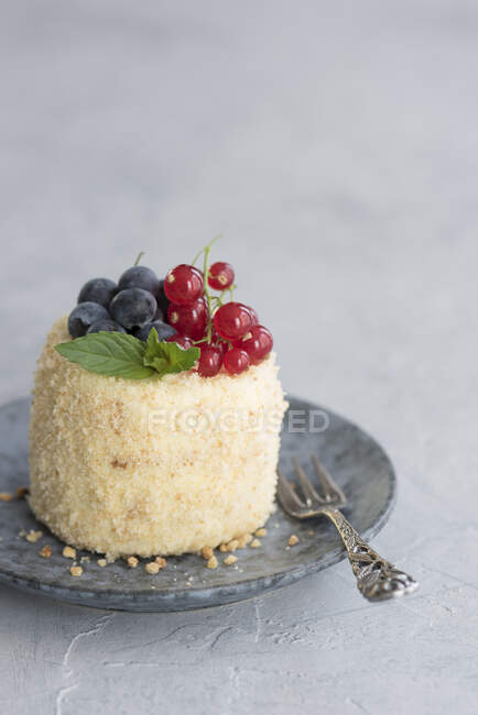 A cream biscuit tart covered with ground almonds and berries — Stock Photo