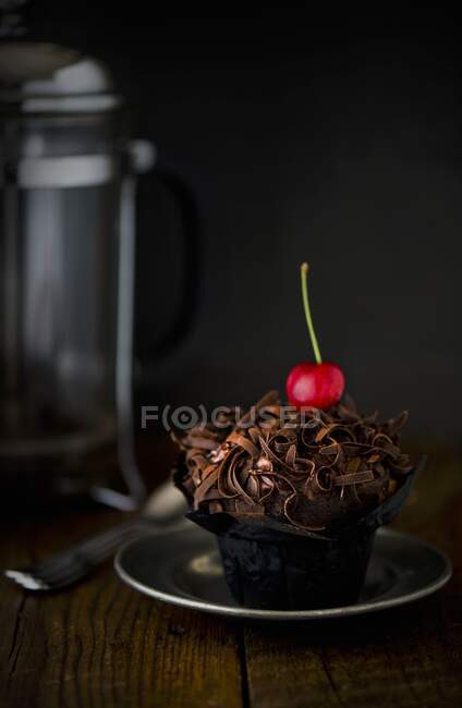 Um cupcake de chocolate com uma cereja — Fotografia de Stock