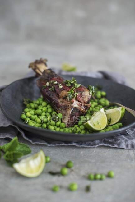 Roasted lamb shanks with peas, mint and lime — Stock Photo
