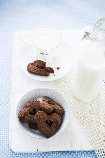 Heart shaped chocolate biscuits and milk — Stock Photo