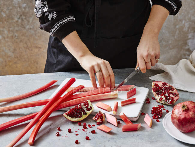 A woman preparing rhubarb and pomegranate — Stock Photo