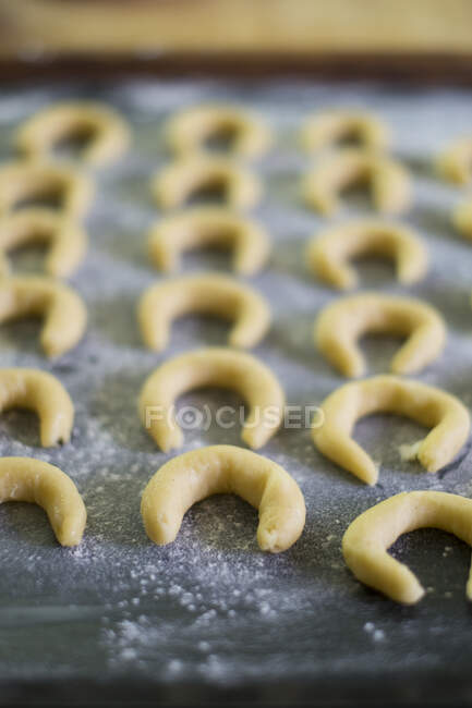 Unbaked vanilla crescent biscuits on a baking tray — Stock Photo
