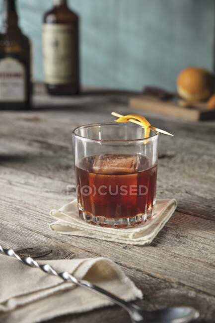 Whisky cherry cocktail garnished with orange peel skewered with toothpick — Stock Photo