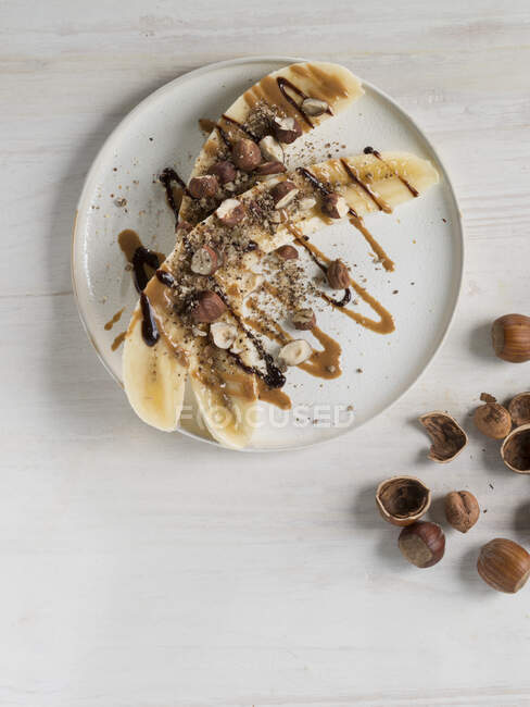 Banane dimezzate con nocciole, burro di nocciole e salsa al cioccolato — Foto stock