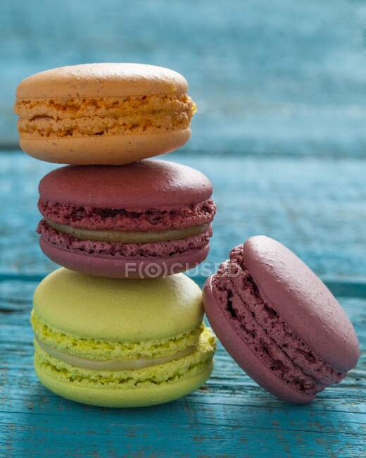 Four macarons on blue wooden background — Stock Photo