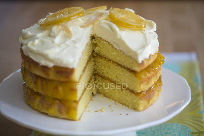 Una torta al limone a tre strati con glassa e limoni canditi — Foto stock