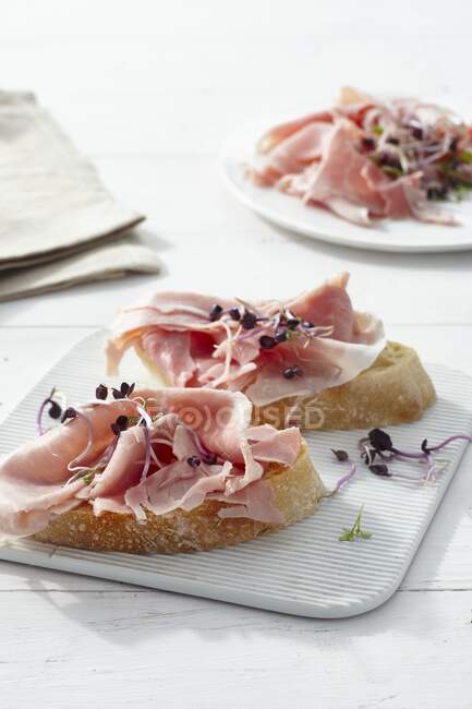 Ciabatta with cooked ham and shoots — Stock Photo