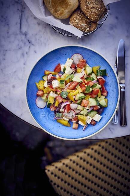 Close-up shot of delicious Greek salad on blue plate — Stock Photo