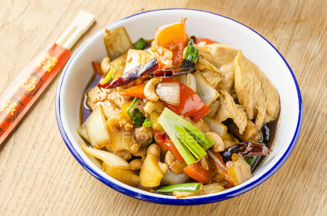 Stir fried chicken with cashew nuts, red peppers, onions, spring onions, pinapple, chilli, carrots in a sweet oyster sauce — Stock Photo