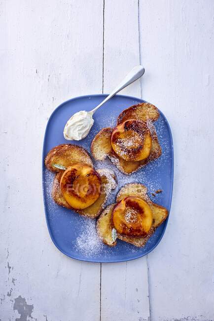 Pain perdu toasts with peaches in sugar powder with spoon — Stock Photo