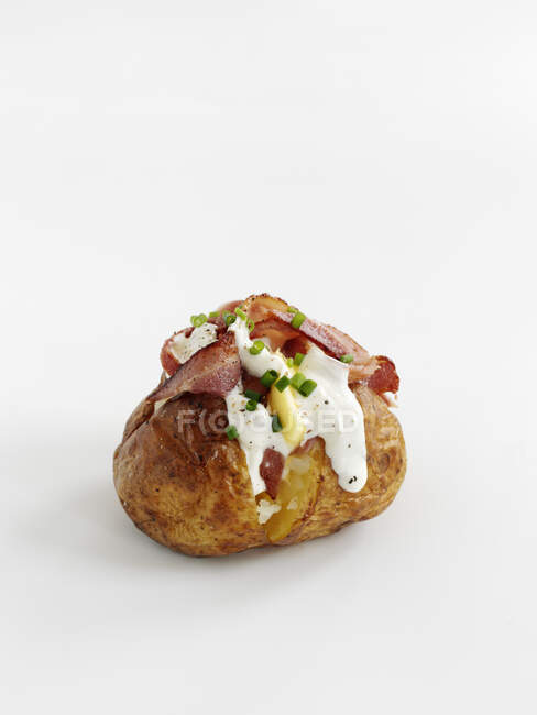 Baked potato with bacon and sour cream — Stock Photo