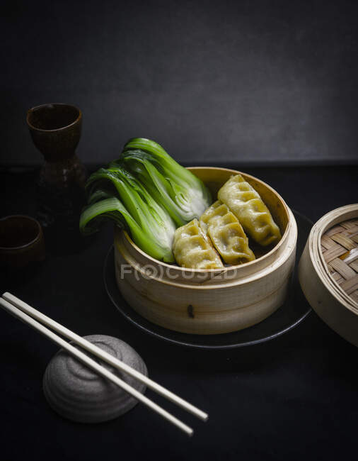 Steamed dumplings with pak choi in bamboo steamer — Stock Photo