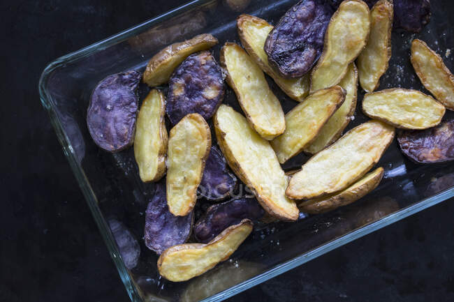 Oven-roasted potatoes in a glass dish — Stock Photo