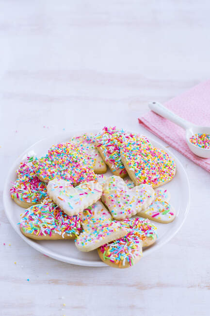 Biscuits en forme de coeur avec des saupoudres colorées — Photo de stock