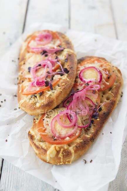 Focaccia with tomatoes, vegan grated cheese and pickled onions (Italy) — Stock Photo