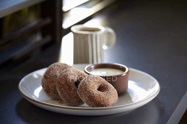 Buckwheat doughnuts with creme anglaise and coffee — Stock Photo