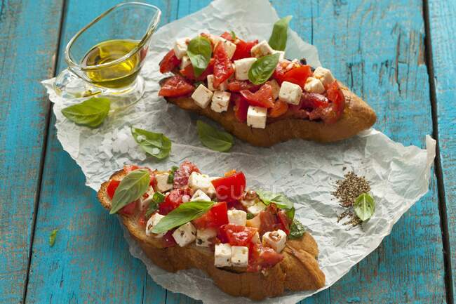 Bread slices with tomatoes, feta and basil — Stock Photo