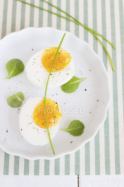 Boiled eggs with pepper and chives — Stock Photo