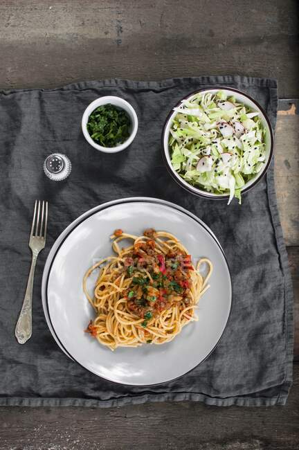 Спагетти с чечевичным соусом и салатом из капусты — стоковое фото