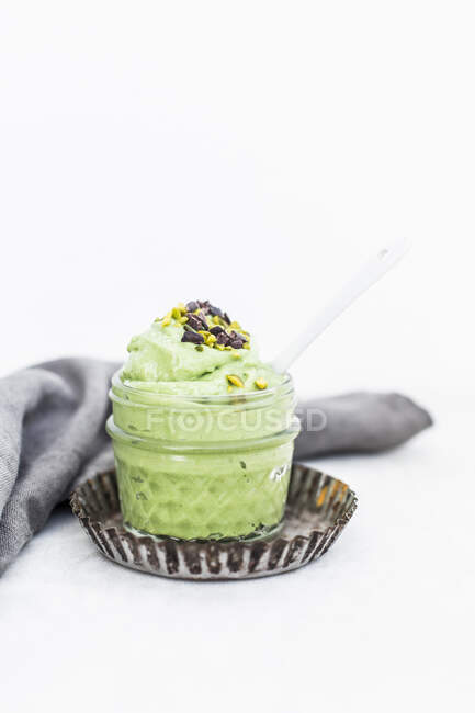 Nice cream made from frozen bananas and avocado topped with pistachios and cocoa nibs — Stock Photo