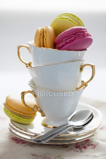 Macarons in teacups close seup view — стоковое фото