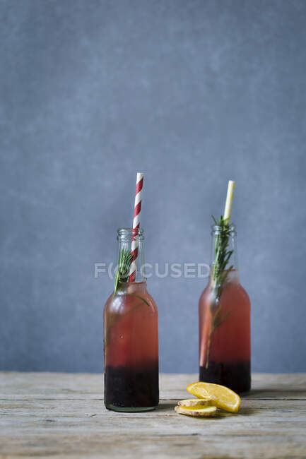 Черника и розмарин с имбирем в двух бутылках — стоковое фото
