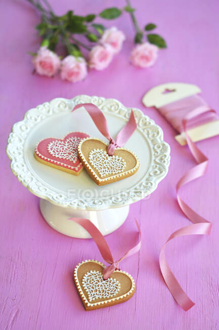 Biscuits colorés en forme de cœur sur un stand de gâteau — Photo de stock