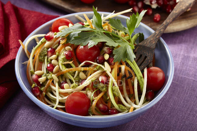 Salad with cocktail tomatoes, courgettes, pine nuts and pomegranate seeds — Stock Photo