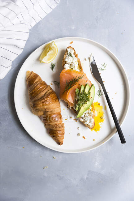 An avocado and salmon croissant — Stock Photo