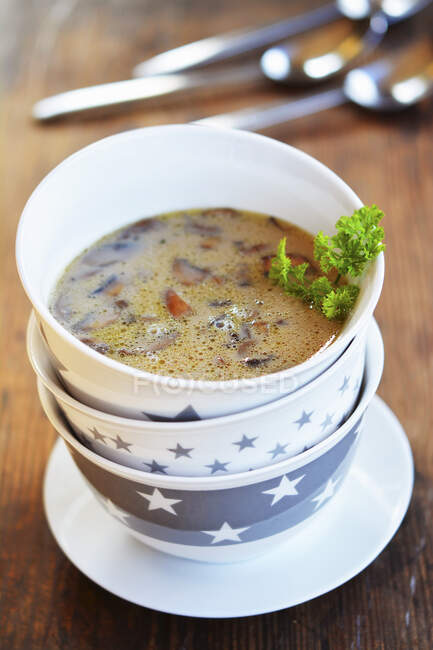 Грибний суп з петрушкою в трьох складених мисках — стокове фото