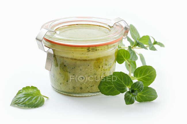 Homemade mint tapenade in a jar against a white background — Stock Photo