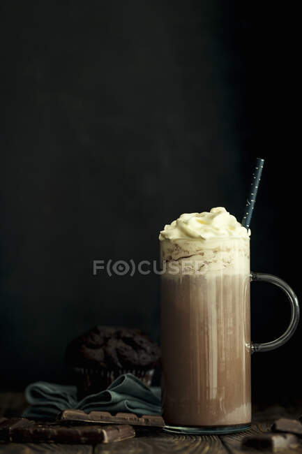 Hot chocolate with whipped cream in a jar with a handle against a black background — Stock Photo