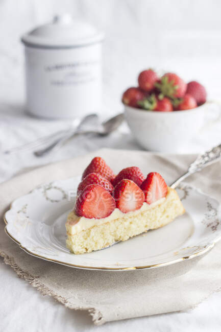 A slice of strawberry cake topped with set custard — Stock Photo
