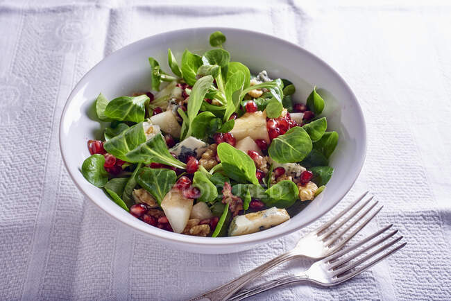 Feldsalat mit Birnen, Gorgonzola, Granatapfelkernen und Nüssen — Stockfoto