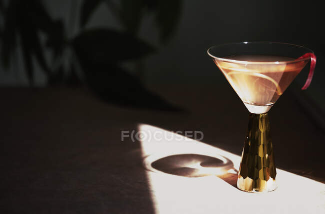 Um coquetel de verão em um vidro caído lançando uma sombra — Fotografia de Stock