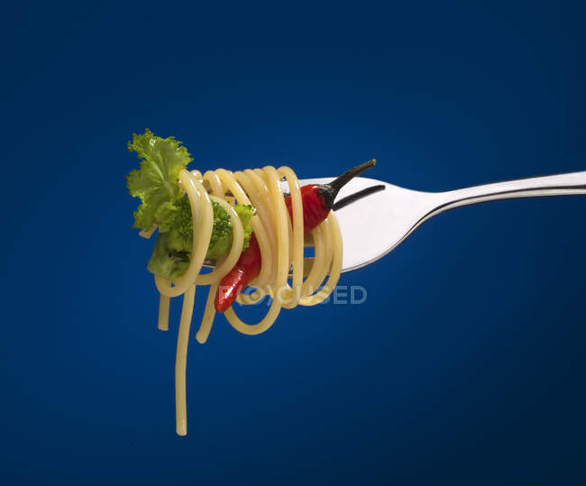 Spaghetti with a chill pepper and broccoli on a fork — Stock Photo