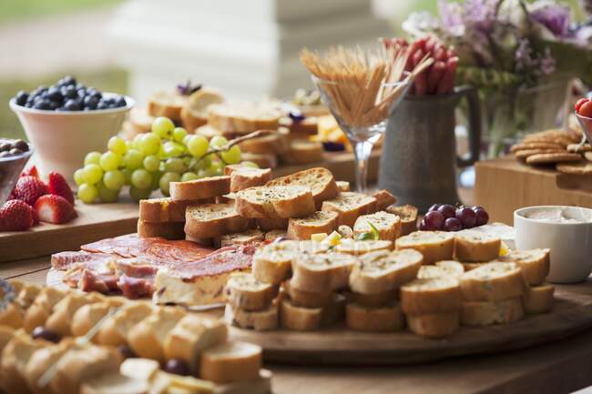 Varios aperitivos de fiesta en una mesa de madera - foto de stock