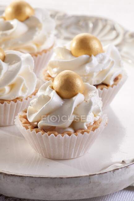 Tartlets with cream and decorative edible gold ball — Stock Photo