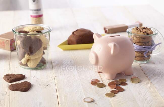 Печиво і скарбничка з деякими монетами на дерев'яному столі — стокове фото