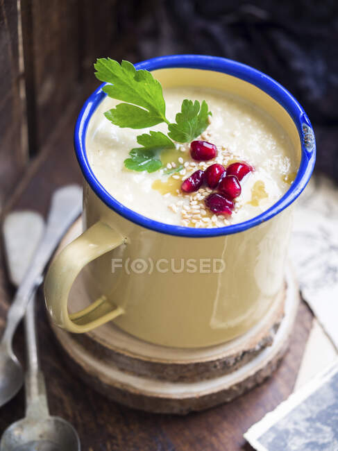 Суп со сливками из цветной капусты со сладким картофелем и тахини в чашке — стоковое фото